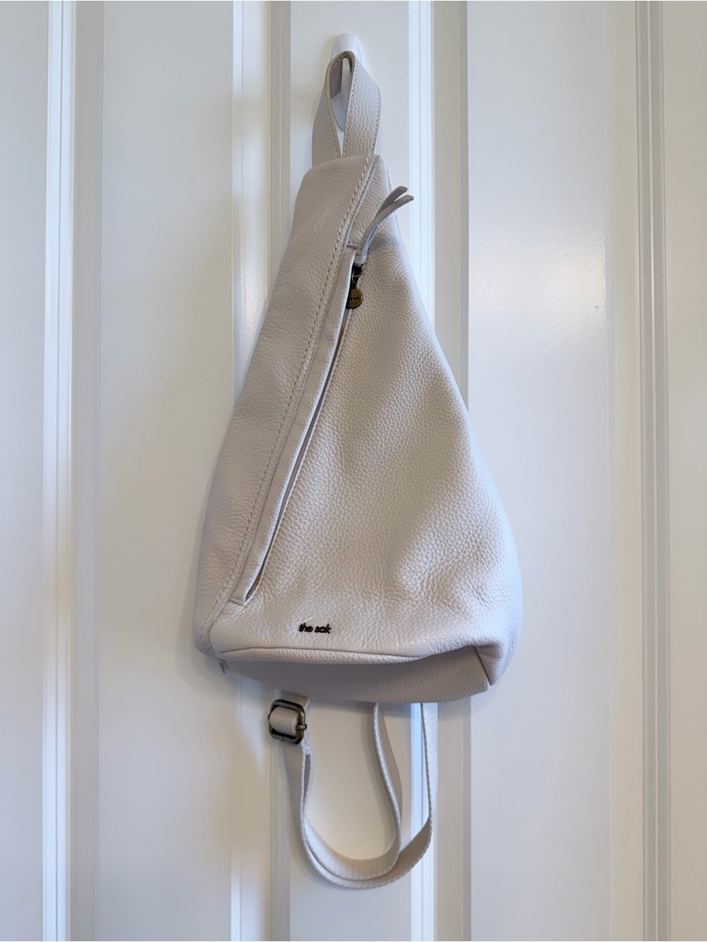 The Sak Geo Sling Pebbled Leather Backpack in Stone / Cream Color